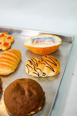 Rainbow filled sweet bread and chocolate striped bread rolls on tray