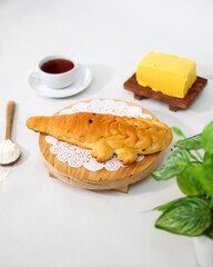 Crocodile shaped bread served on wooden plate with tea and butter