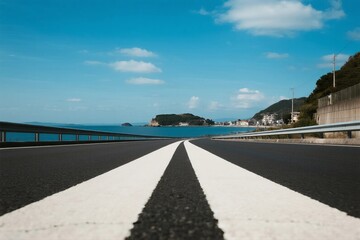 Fototapeta premium Straight road leading to a scenic coastal view under clear blue sky