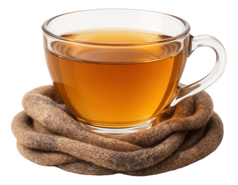 Glass teacup of chamomile tea resting on folded woolen scarf in muted earth tones