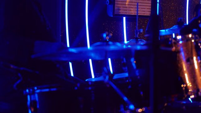 Drum player close-up during live concert, highlighting music talent, percussion instruments, and stage performance