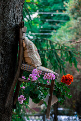 garden tree and hanging chair decorative postmodernism object with blossom flowers spring time vertical photo