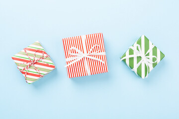 Fototapeta premium Many striped Christmas gift boxes on color background, top view