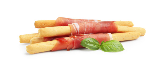 Delicious grissini sticks with prosciutto and basil isolated on white