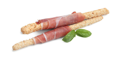 Delicious grissini sticks with sesame seeds, prosciutto and basil isolated on white
