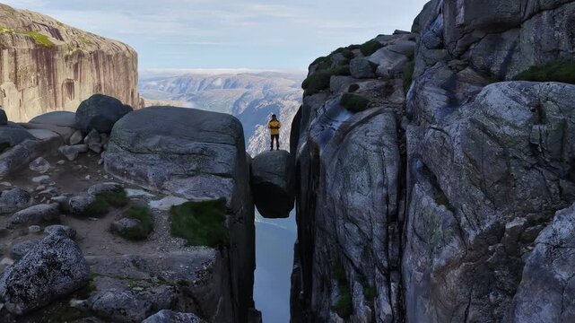 Aerial view of a hiker standing on kjeragbolten boulder in norway