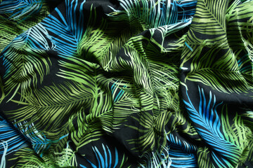 Creased black, green and blue fabric with palm leaves pattern