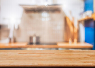 Wooden kitchen table with blurred cooking interior background