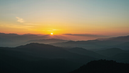 Fototapeta premium 低い太陽が霧の層を透かしながら稜線を縁取り色相の移ろいが上質な印象を残すブランドタイアップにも使いやすいクリーンな朝景.生成AI