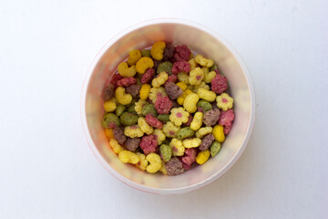 A bowl of colorful cereals isolated on white background.