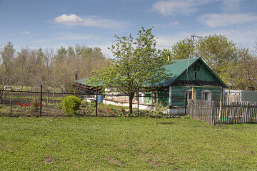 A green house with a fence in front of it