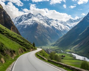 Fototapeta premium Winding Road Through a Lush Green Valley with Snow- Capped Mountains and a Village image photo