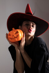 Halloween Witch holding Pumpkin lantern over black background. Decoration