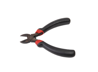 Well used diagonal cutting pliers with black and red handles isolated black.