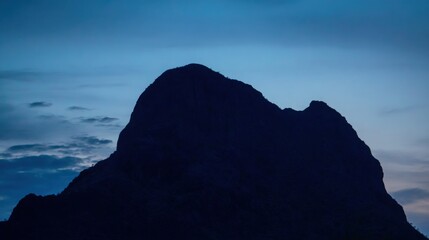 quiet. A majestic mountain silhouette against a twilight sky, radiating calm and natural beauty. travel magazines, destination branding, designed for outdoor magazines and nature guides.