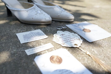 Romantic wedding day details with bridal shoes, gold rings, and personalized stationery with wax seals