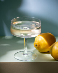 Drink in a glass, blue background, lemons, deep shadows