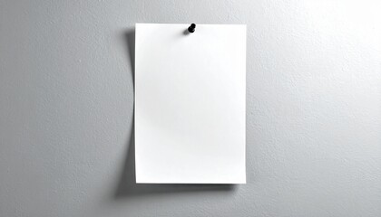 Minimalist composition showing a blank white note pinned to a smooth gray wall, with soft lighting and shadow for a realistic mockup