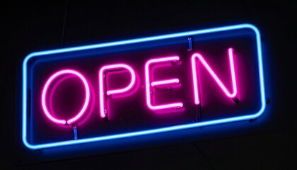 A vibrant pink neon open sign with a blue rectangular border glows brightly in the dark, symbolizing a welcoming business