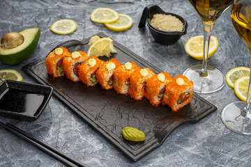 Philadelphia sushi set in caviar on slate on a gray concrete background with decor