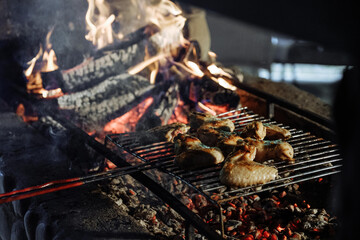 Chicken wings grilling over a roaring fire
