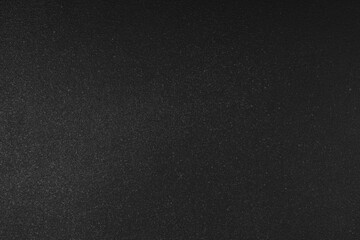 Abstract shiny, radiant texture background with different shades of dark black color. Painted canvas, glitter concrete surface, studio backdrop, grainy textured effect