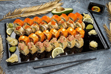 mega large sushi set Philadelphia in a black plate on a table with decor