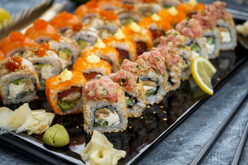Philadelphia sushi set on a large black tray with soy sauce