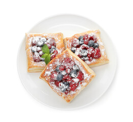 Tasty puff pastries with berries, powdered sugar and mint isolated on white, top view
