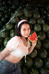Beautiful young Asian woman with Watermelon in market fruit shop.