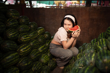 Beautiful young Asian woman with Watermelon in market fruit shop.