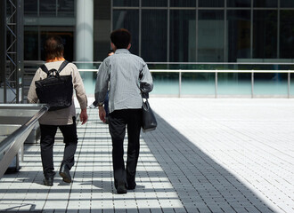 夏の昼の都市の商業施設の広場で歩く女性買い物客の様子