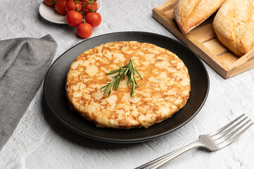 Traditional Spanish tortilla, omelette with potatoes served on black dish 