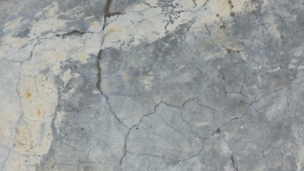 Old grey concrete floor with stains, fading, peeling paint, scratches, sidewalk, road surface, texture, and background image.