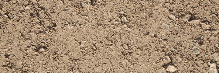 Brown fresh pressed sand and gravel country road background. Wide banner. Closeup. Top down view.