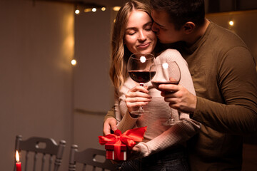 Couple in love celebrating Valentine's day having dinner with wine at home. Happy Valentines Day