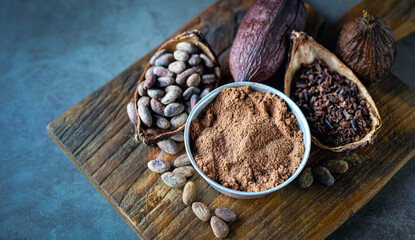 Top view of cocoa powder with cocoa bean and cocoa nibs, cacao pods on gray background