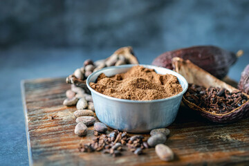 cocoa powder with cocoa bean and cocoa nibs, cacao pods on gray background