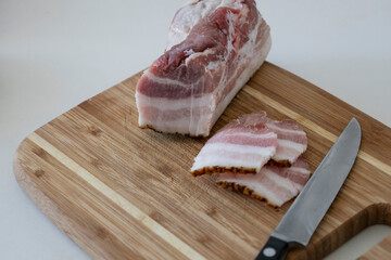 Ukrainian traditional cuisine. Very tasty pieces of salo. Raw ukrainian bacon or salo on wooden board. Sliced salted pork lard (salo). Food concept.