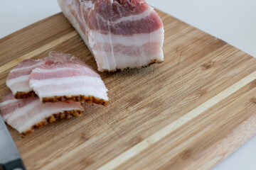 Ukrainian traditional cuisine. Very tasty pieces of salo. Raw ukrainian bacon or salo on wooden board. Sliced salted pork lard (salo). Food concept.
