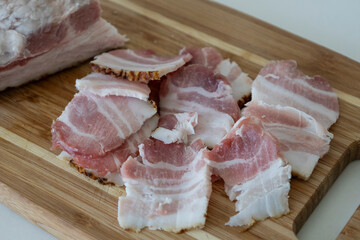 Ukrainian traditional cuisine. Very tasty pieces of salo. Raw ukrainian bacon or salo on wooden board. Sliced salted pork lard (salo). Food concept.
