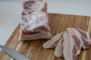 Ukrainian traditional cuisine. Very tasty pieces of salo. Raw ukrainian bacon or salo on wooden board. Sliced salted pork lard (salo). Food concept.