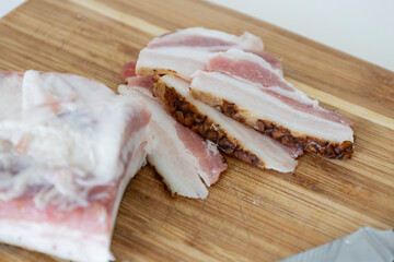 Ukrainian traditional cuisine. Very tasty pieces of salo. Raw ukrainian bacon or salo on wooden board. Sliced salted pork lard (salo). Food concept.