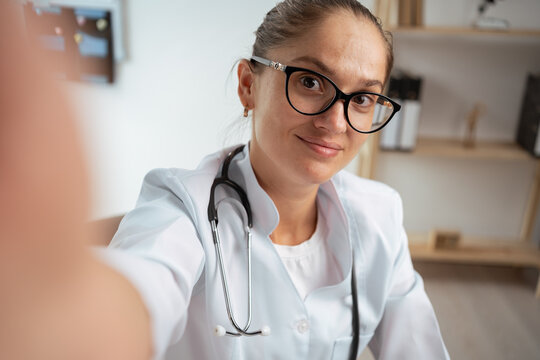 female doctor taking selfie photo in hospital office. doctor makes video call from her workplace. copy space