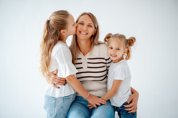 mother with children and daughters, maternal love and care, mother and child hug and kiss on a white isolated background, a family with two children