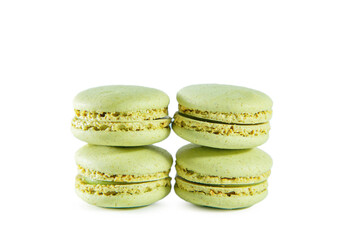 Four green pistachio macaroons isolated on white background.