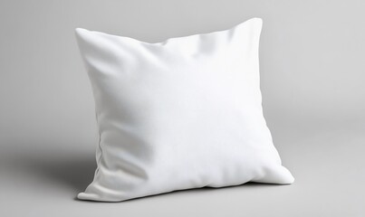Isolated white square pillow casting soft shadows on a neutral gray surface