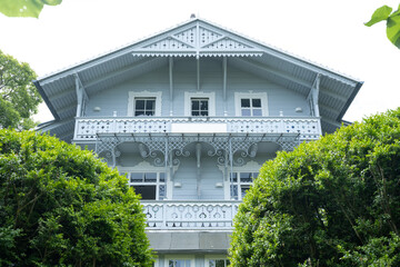 Historic seaside villa with ornate wooden balcony and decorative architecture