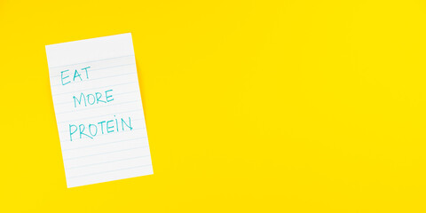 Eat more protein Health goals, healthy eating habits on sticky yellow note posted on a reminder pad...