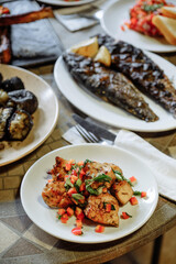 Delicious Grilled Fish and Chicken Dishes on a Table